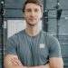 young bodybuilder standing in gym with arms crossed and looking at camera. Healthy youth, bodycare and active lifestyle concept.
